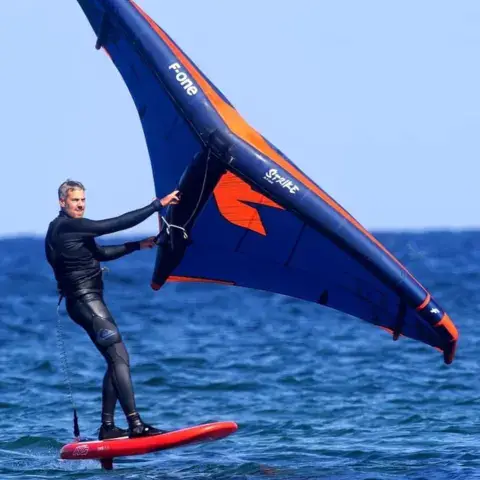 Un pratiquant de wing foil sous une aile F-one