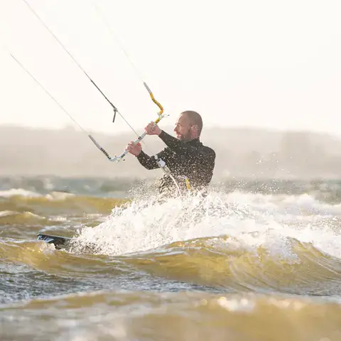 Kitesurfeur tenant sa barre sur une mer agitée