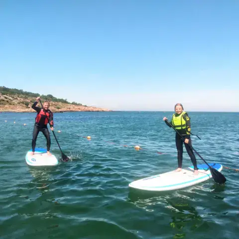 Sortie de paddle en eau calme le long d'une côte rocheuse
