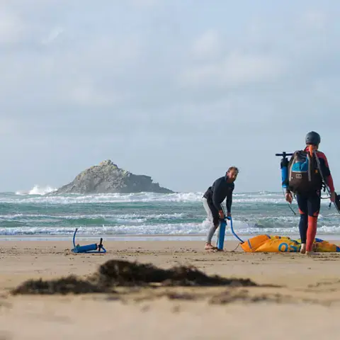 Kitesurfeurs sur la plage avec leur matériel