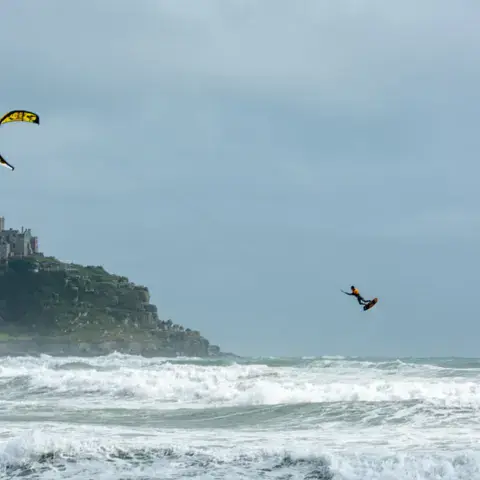 Kite dans le ciel devant un îlot rocheux