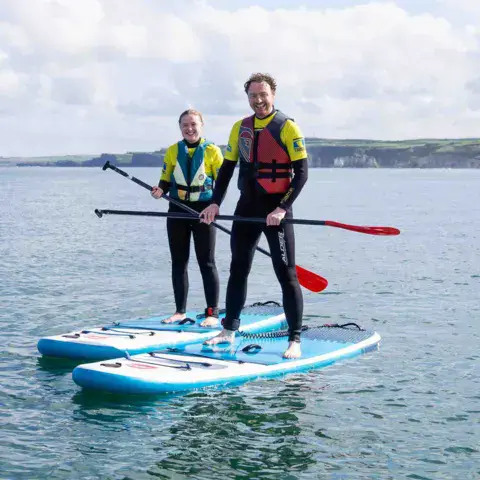 Deux personnes debout sur des paddles
