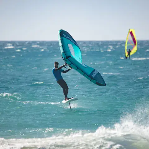 Wingfoiler et kitesurfeurs sur une mer agitée