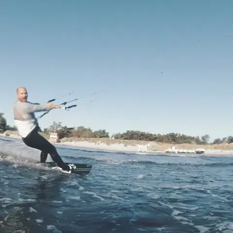 Kitesurfeur en navigation près d'une plage