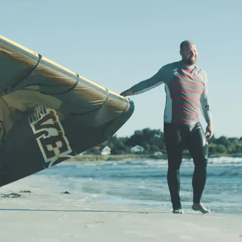 Kitesurfeur qui tient son aile sur la plage