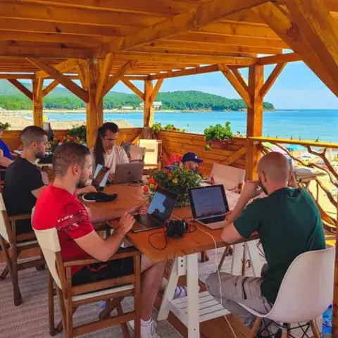 Terrasse couverte en bois, avec des personnes à table