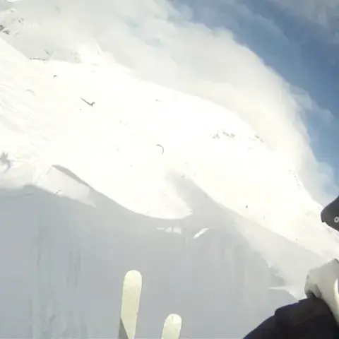 Barre de kite en main, skis au-dessus de la neige