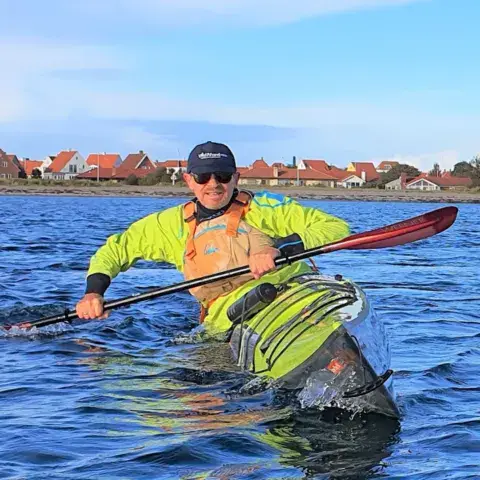 Kayakiste en gilet jaune sur l'eau