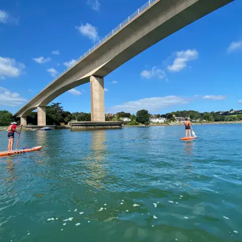 Pratiquants de paddle sous un pont