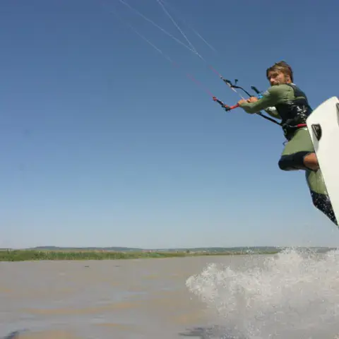 Saut de kitesurf avec une planche blanche