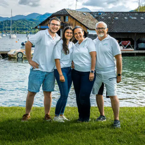 L'équipe au bord de l'eau devant le hangar à bateaux