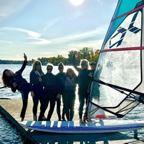 Groupe sur un ponton avec une planche à voile