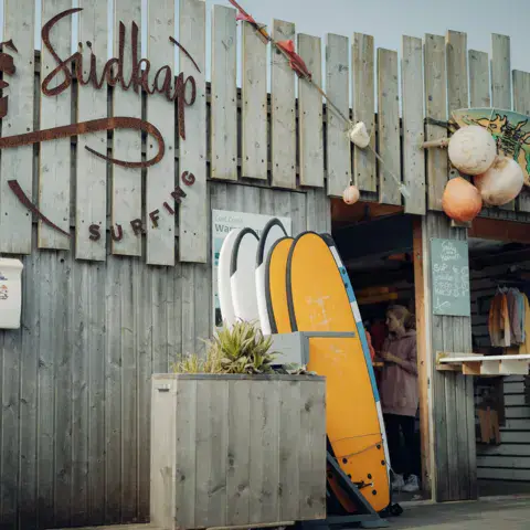 Cabane de l'école, avec planches de surf appuyées devant
