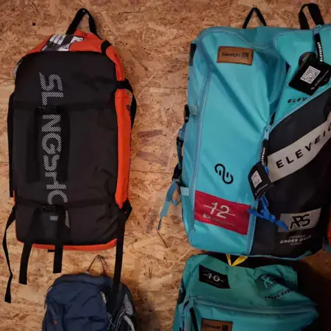 Sacs de kite rangés contre un mur de bois