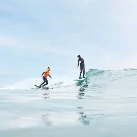 Deux surfeurs sur une vague pendant un cours