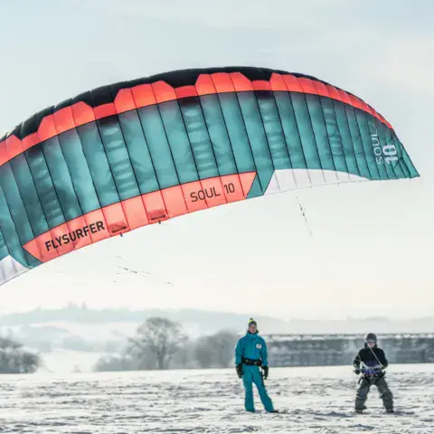 Kite de snowkite déployé sur un terrain enneigé