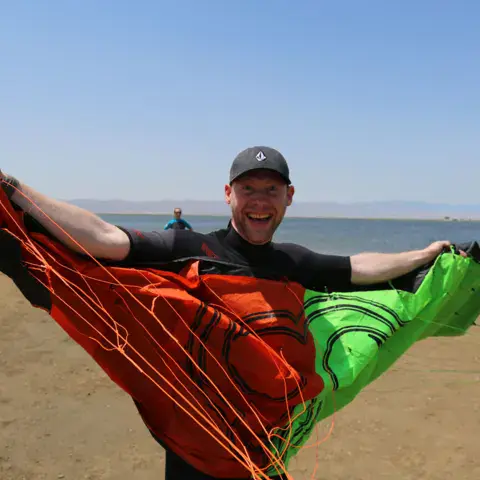 Préparation d'une aile de kite sur la plage
