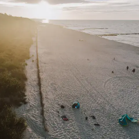La plage vue du ciel, avec des ailes de kite posées sur le sable