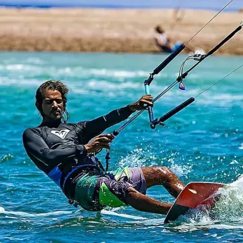 Un kitesurfeur sur l'eau turquoise de la lagune