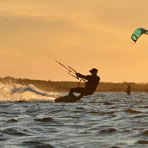 Un kitesurfeur à la tombée du jour