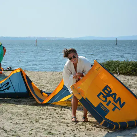 Préparation d'une aile de kite sur la plage