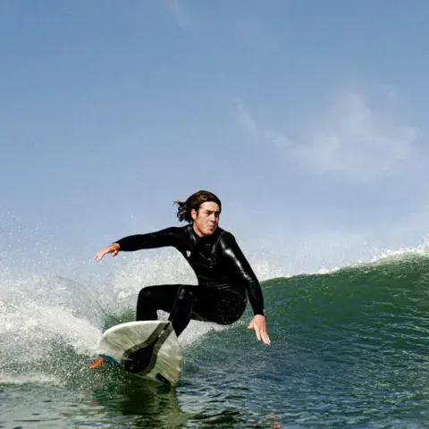 Surfeuse en virage sur une vague