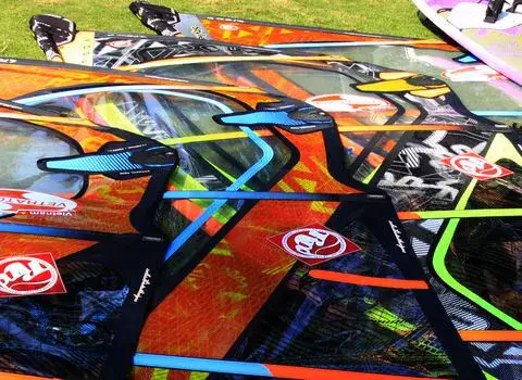 Voiles de windsurf étalées sur la pelouse du centre