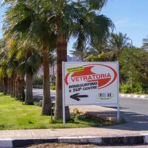 Le panneau d'accès au centre Vetratoria, sous les palmiers