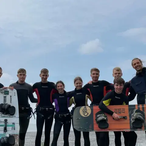 Groupe de kitesurfeurs avec leurs planches