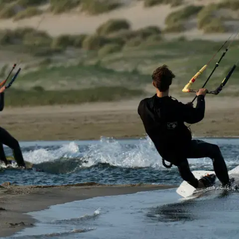 Deux kitesurfeurs près des dunes
