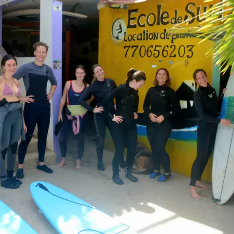 Élèves en combinaison devant l'école de surf