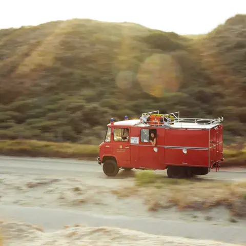 L'ancien bus de pompiers de l'école roulant près des dunes