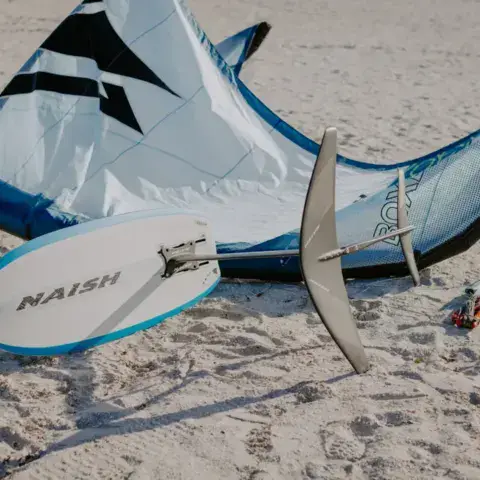 Kite et planche de foil posés sur le sable