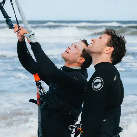 Moniteurs devant la mer, kite en main