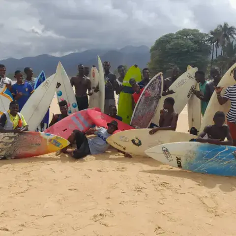 Groupe de surfeurs avec leurs planches sur la plage de Bureh