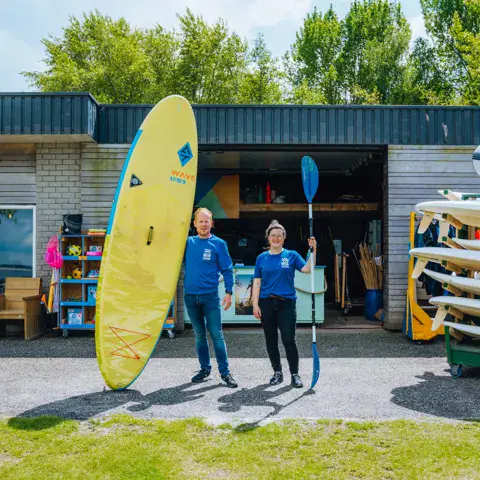 Équipe devant le local avec planche et paddles
