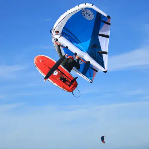 Pratiquant de wingfoil en plein saut