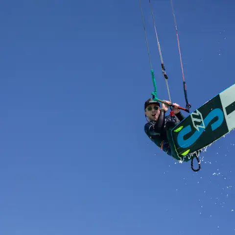 Un véliplanchiste en pleine glisse sur une eau turquoise