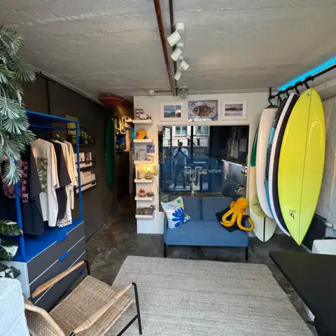 Intérieur de la boutique avec planches de surf et vêtements
