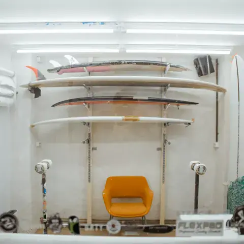 Planches de surf exposées dans la vitrine de l'atelier