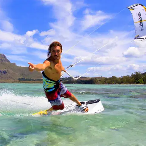 Un kitesurfeur sur l'eau turquoise du lagon