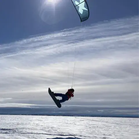 Rider en plein saut sur une étendue enneigée