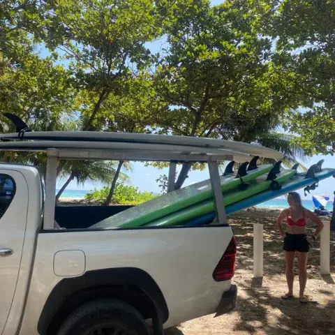 Camionnette chargée de planches de surf sur le parking de la plage