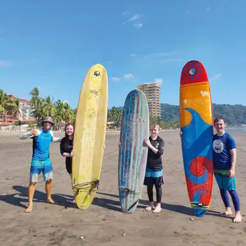 Groupe d'élèves avec leurs planches sur la plage
