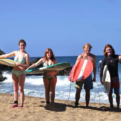 Un groupe de surfeurs sur la plage avec leurs planches