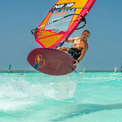 Windsurfeur en saut sur le plan d'eau