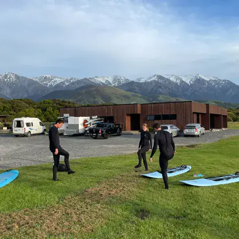 Surfeurs sur la plage au coucher du soleil