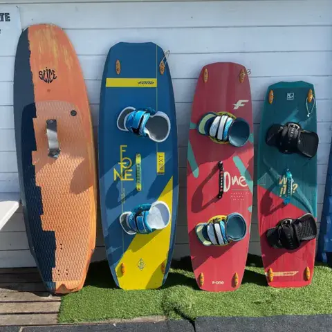 Planches de kitesurf rangées devant le local de la base