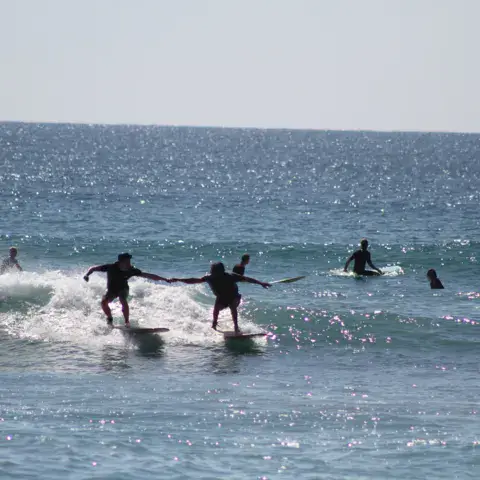 Groupe de surfeurs dans les vagues