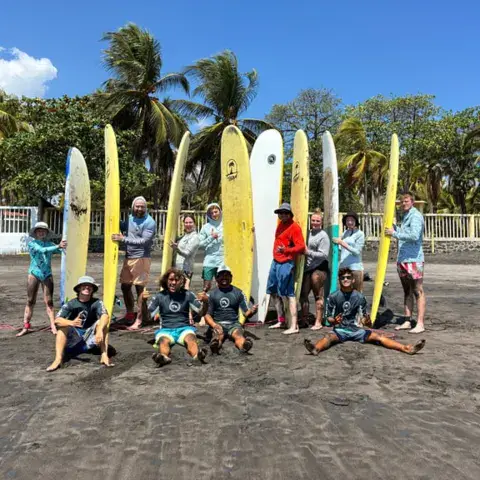 Groupe de surfeurs avec leurs planches sur le sable